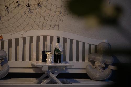a white bench with a table with drinks on it at Captain's Suite in Neusiedl am See