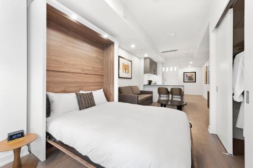 a bedroom with a white bed with a wooden headboard at reStays Ottawa in Ottawa