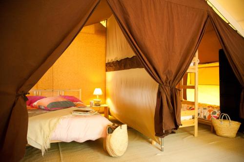 a bedroom with a bed in a tent at Tente Lodge La Téouleyre in Saint-Julien-en-Born