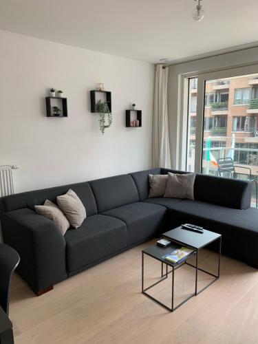 a living room with a blue couch and a table at Nieuwbouwappartement Lippenslaan, 2 -Slaapkamers in Knokke-Heist