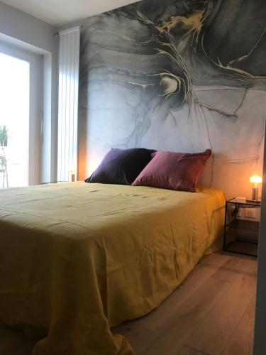 1 dormitorio con 1 cama con una pintura en la pared en PLUS PRES DES ETOILES en Annecy