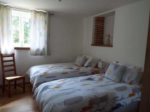 1 dormitorio con 2 camas y ventana en Gîte La Peyre en Le Grand-Bourg