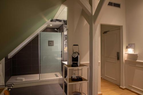 a bathroom with a walk in shower next to a staircase at Hôtel et Spa La Villa K - Basel Airport in Saint-Louis