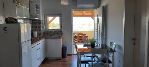 a small kitchen with a table and a refrigerator at Apartment Sanja in Zadar