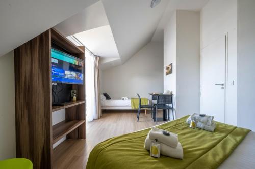 a bedroom with a green bed with a television at ATHOME RESIDENCE ET SPA in La Rochelle