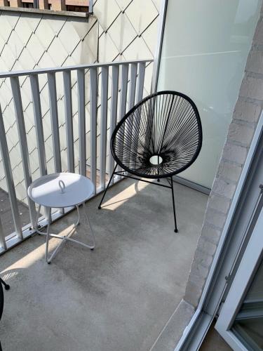 a black chair and a table on a balcony at Nieuwbouwappartement Lippenslaan, 2 -Slaapkamers in Knokke-Heist