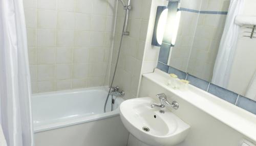 a bathroom with a sink and a toilet and a tub at Campanile Lille Sud - Douai Cuincy in Cuincy