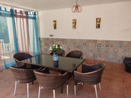 een eetkamer met een glazen tafel en stoelen bij Villa Castillo Nuevo with optional Heated Private Pool in San Miguel de Salinas