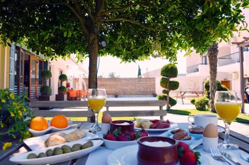 a table topped with plates of food and glasses of wine at Syrtaki Hotel in Ofrínion