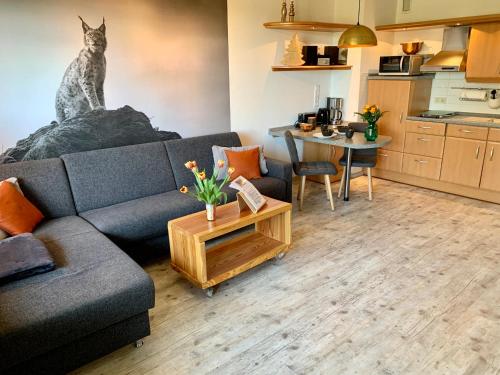 ein Wohnzimmer mit Sofa und Tisch in der Unterkunft Luchsbutze in Sankt Andreasberg