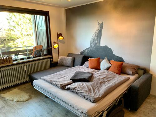 ein Schlafzimmer mit einem Bett mit einem Katzenbild an der Wand in der Unterkunft Luchsbutze in Sankt Andreasberg