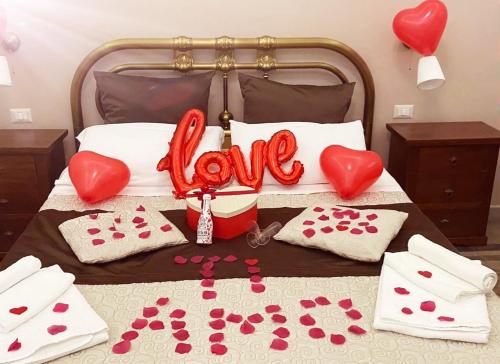 a bed with hearts and the word love on it at Le Suite del Teatro cucinino privato in Taranto