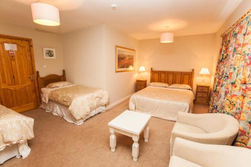a hotel room with two beds and a couch at Sunville Bed And Breakfast in Ballycotton