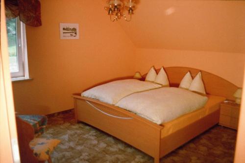 ein Schlafzimmer mit einem Bett mit weißen Kissen darauf in der Unterkunft Pension Annelie in Schullwitz