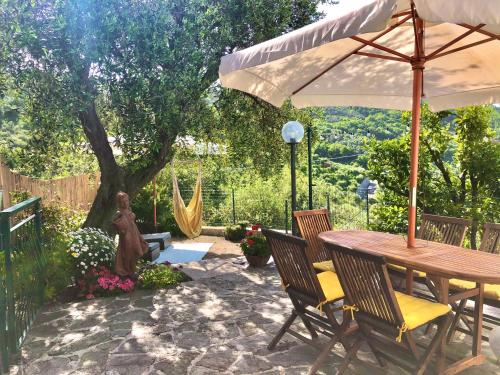 a patio with a table and chairs and an umbrella at Foglie d'Argento in Moneglia