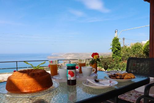 uma mesa com comida e bebidas numa mesa com vista em Roussa's View Apartments em Sitia