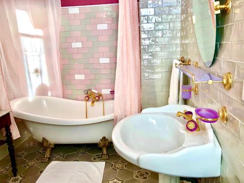 Baño de color rosa con bañera y lavamanos en Chateau Gunes (Guges) en Cissac-Médoc