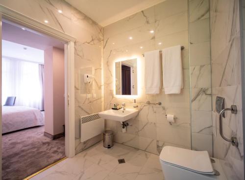 a bathroom with a sink and a toilet and a shower at The Moon Boutique Hotel in Sofia