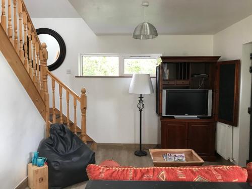 a living room with a couch and a television at Lakeside Lookout Bantry in Cork