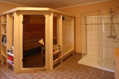 ein Bad mit einer Dusche und einer Glastür in der Unterkunft Pension Annelie in Schullwitz