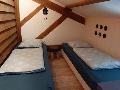 Cette chambre mansardée comprend 2 lits et des poutres apparentes. dans l'établissement Rimbes Casteljaloux - gite 6 pers Rustique, à Casteljaloux
