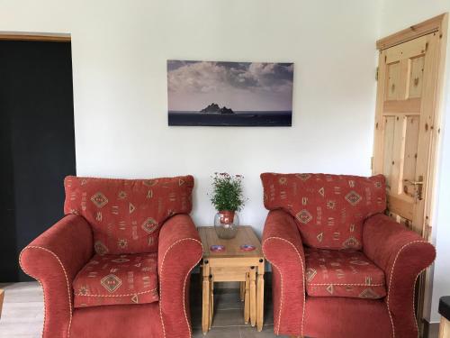 two red chairs and a table in a room at Lakeside Lookout Bantry in Cork