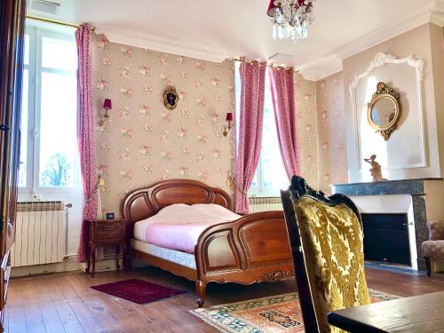 una camera da letto con letto, lenzuola rosa e camino di Chateau Gunes (Guges) a Cissac-Médoc