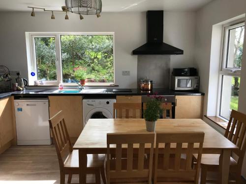 a kitchen with a wooden table and a table and chairs at Lakeside Lookout Bantry in Cork