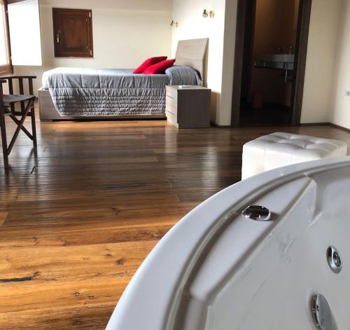 a bath tub in a room with a wooden floor at Corte Fratini Appartamenti in Trevi