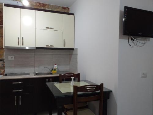 a kitchen with a table and chairs and a tv at Grand Seaview Apartments in Ksamil