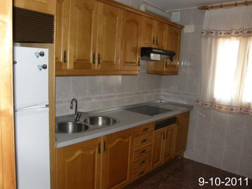 cocina con fregadero y nevera blanca en Apartamento EL BALCON, en Cuenca