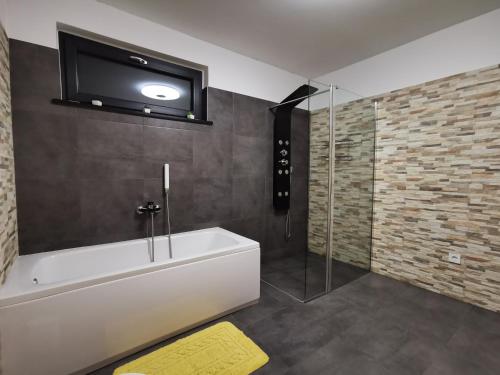 baño con bañera y TV en la pared en Apartman Lejla, en Poreč
