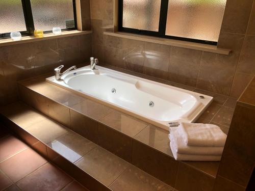 a bath tub in a bathroom with a window at Coastal Chalet Suites Whangaroa in Kaeo