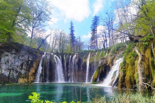 a waterfall in the middle of a river at Plitvice Streaming in Prijeboj