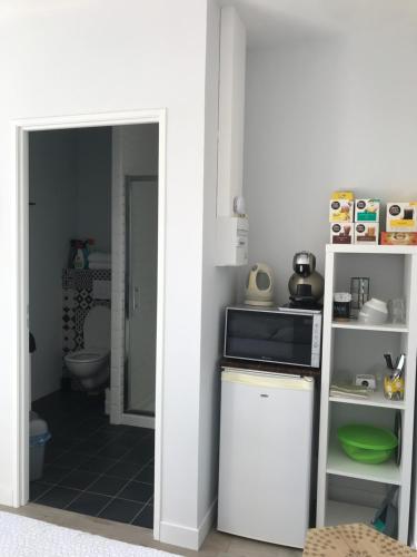 a kitchen with a stove and a microwave in a room at les aulnes de sanguinet in Sanguinet