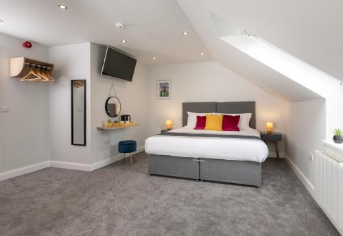 a bedroom with a king sized bed in a attic at Stableside Hostel at York Racecourse in York