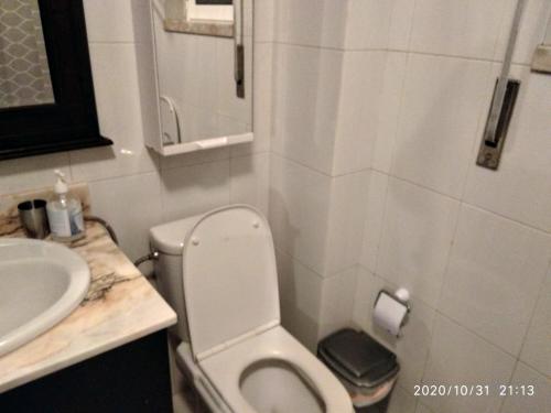 a small bathroom with a toilet and a sink at Quartos Cesário Verde Massamá in Queluz