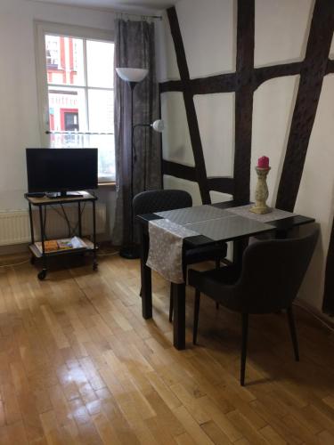 une salle à manger avec une table, des chaises et une télévision dans l'établissement Ad Monte, à Cochem