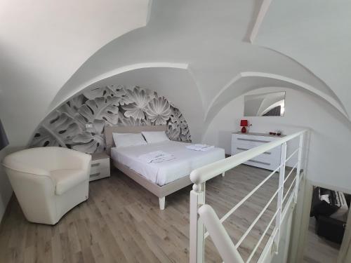 una camera con un letto bianco e una scala di Casa Le Site a Palmariggi