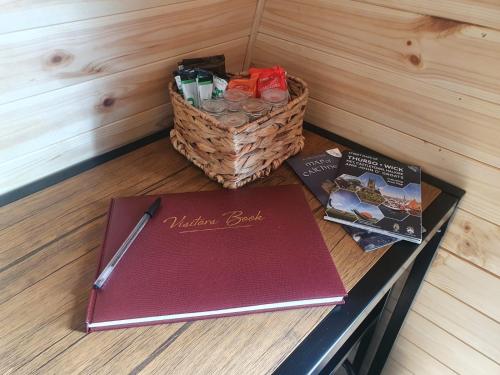a table with a notebook and a basket of books at North Point Pods (north coast 500) in Thurso