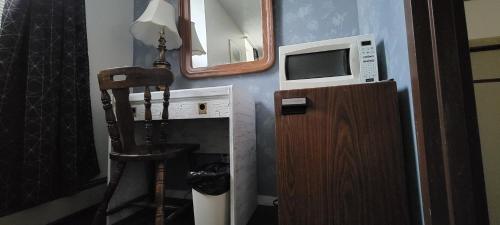 a kitchen with a sink, stove, and microwave at Cosmopolitan Hotel in Blairmore