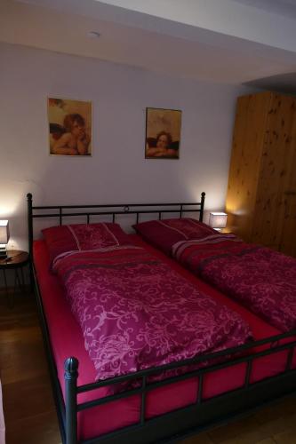 a bedroom with a large bed with red sheets at Ad Monte in Cochem