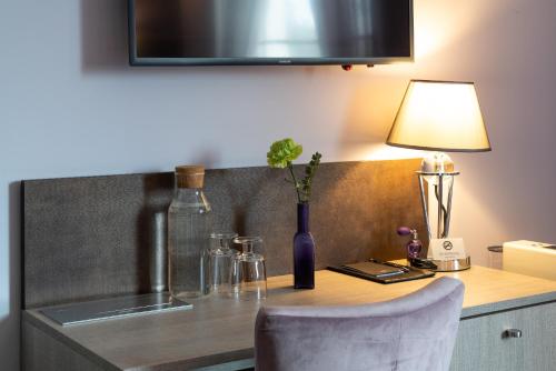 a kitchen counter with a table with a bottle and a lamp at Lavender Inn Guest House in Viešvėnai