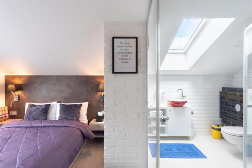 a bedroom with a purple bed and a bathroom at Lavender Inn Guest House in Viešvėnai