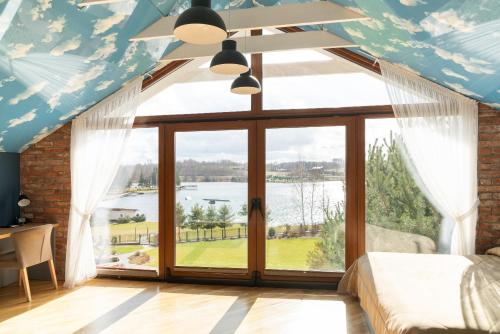 a bedroom with a large window with a view of the water at Lavender Inn Guest House in Viešvėnai