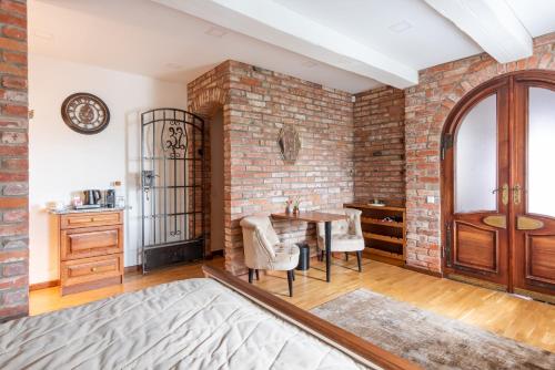 a dining room with a brick wall and a table at Lavender Inn Guest House in Viešvėnai
