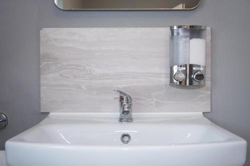 a bathroom sink with a faucet on top of it at VIP Church View Apartment in Portadown