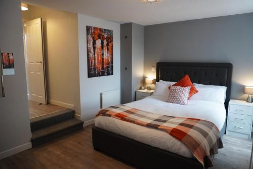 a bedroom with a bed and a picture on the wall at VIP Church View Apartment in Portadown