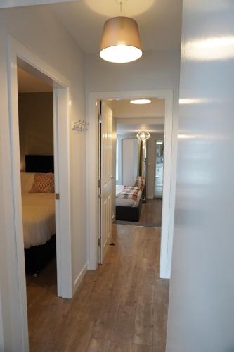 a hallway of a bedroom with a bed and a couch at VIP Church View Apartment in Portadown
