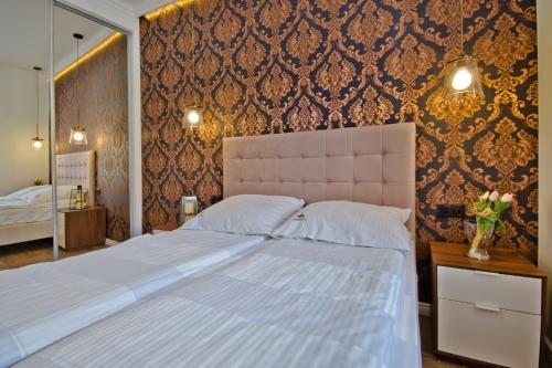 ソポトにあるImperial Apartments - Haffner Luxの白い大型ベッドと壁が備わるベッドルーム1室が備わります。